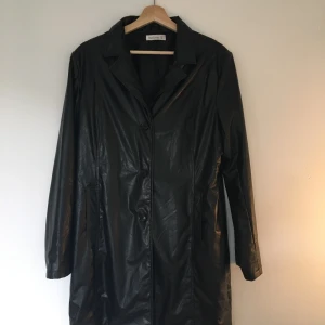 Lång skinnjacka storlek L - En svart mellan lång fake skinnjacka i storlek L