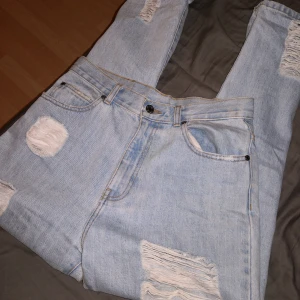 Ripped Dr.Denim mom jeans  - Ett par nästan oanvända mom jeans från Dr. Denim i en ljusblå ripped modell. Stl 28/40, S/M beroende på hur man vill att den ska sitta. 