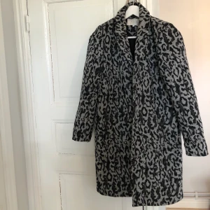 Leopardkappa  - Grå leopardkappa från Vila. Går till knävecket. Använd en säsong, i mycket bra skick. Köparen står för frakten 💓