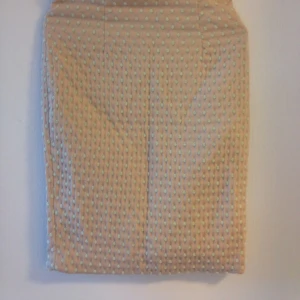  - Figurnära kjol i tyg med struktur, beige och ljust grönt. Sitter något högre i midjan, och slutar precis vid knät (beror på längd såklart!) Liten slits bak. Perfekt för både kontor och fest!