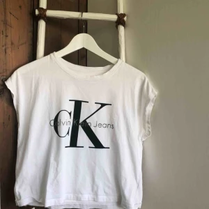  - Jag säljer denna enkla men snygga Calvin Klein Jeans T-shirten som är kortare och bredare i modellen med ”avskurna” ärmar. Den är använd men fortfarande i väldigt bra skick🐚 Köparen står för fraktkostnaden