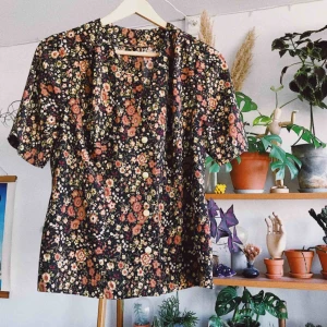  - Underbar vintageblus med fina knappar och blommor! Det står ingen storlek men skulle tippa på S/M. Köparen står för frakt, kan eventuellt mötas upp i Stockholm också!