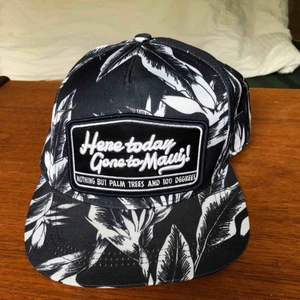  - Blåvit keps med ”here today gone to Maui” inbroderat. Justerbar rem där bak. Frakt tillkommer 