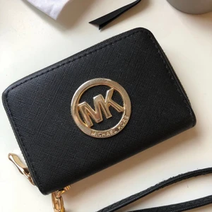 Michael kors plånbok - Svart MK plånbok med gulddetaljer. Skulle tippa på att den är ungefär 13cm lång och 8cm hög. Den är i fint skick, nästan aldrig använd.
