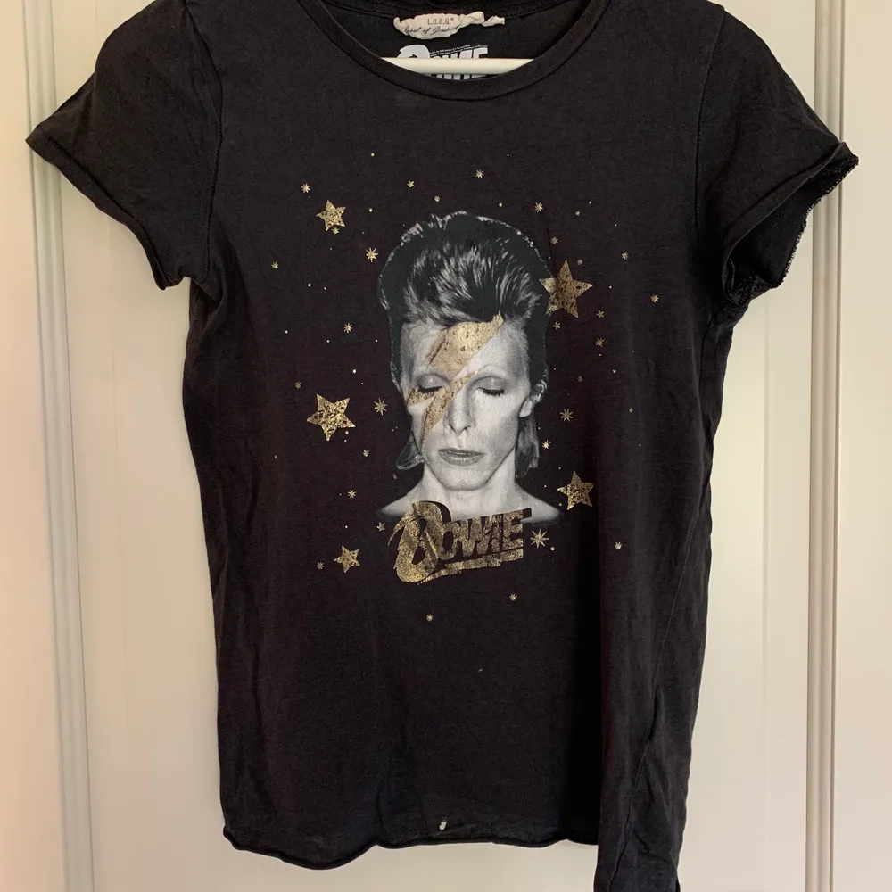 Säljer min t-shirt från H&M med guldiga stjärnor och en bild av david bowie. Ganska använd därav priset. Frakt 63 kr. T-shirts.