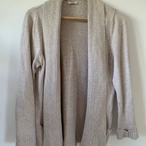 Öppen stickad kofta i storlek 42 - Härligt tung. Faller snyggt! Storleken passar även mig som normalt har 36/S.