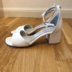 Vita klackskor  - Vita klackskor från Marco Tozzi, storlek 37. Använda en gång. Nypris 399 kr.