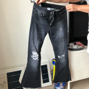 Dondup jeans - Fräcka jeans från Dondup med hål och slitningar framtill. Kick Flare i modellen, alltså korta och utsvängda. Ursnygg grå tvätt. Storlek W27