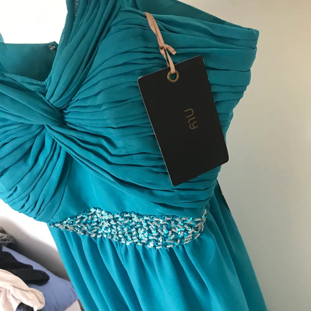 Säljer en jättefin klänning som passar perfekt till bal, den är blå/turkos (teal)  i storlek 40 från Nelly med alla lappar kvar då den är oanvänd. Klänningar.