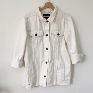 Oversize Jenasjacka  - Vit trendig jeansjacka köpt på 2hand. Är en XS/ Soch på mig är den oversize så passar säkert även M. Jackan är sparsamt använd. Har dock ett litet hål i ryggen, vilket ser ut som en slit-detalj. 