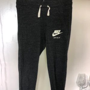 Nike mjukisbyxor - Mörkgrå mjukisbyxor från Nike, storlek XS, nyskick men har växt ur dom. Säljer även hoodien till settet!