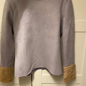 Mysig hösttröja! - Säljer tröja med mockaimitation och fuskpäls på ärmarna. Köpt på zara och är i storlek M. Färgen är grå. Vänligen hör av er vid frågor. Frakt tillkommer på 40kr. 