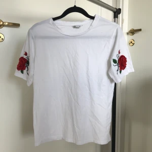 T-shirt storlek XS - En super fin t-shirt med rosor på ärmarna från Cubus, använd 1 gång. Ganska stor i storleken.