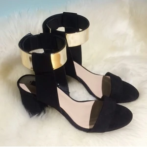 Zara klackar 37 guld detalj - Färg: svart.  Strl: 37.   Snygga klackar från Zara. Sluts igen med dragkedja. Tjock klack. Snygg guld detalj vid vristen. OBS. Aldrig använda, helt NYA i kartong med lappar! Frakt tillkommer, betalning via swish.