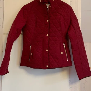 Vinröd jacka strl S/M - Jättefin vinröd rutig jacka med guldknappar Se bild 2 för mer rätt färg (ej klarröd)  Köpt från Tessie Strl M, men liten i storlek Aldrig använd pga fel storlek, lapp kvar Nypris 699