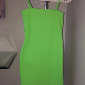 Neon Grön klänning - Använd endast en gång, smala axelband, klänningen går ner till knäna på mig (164cm) köptes från JFR