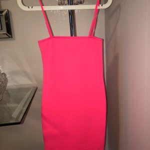 Neon klänning  - Helt oanvänd Neon rosa klänning som går till knäna med smala axelband, strl xs-s, skönt och bra materia, köptes från JFR 