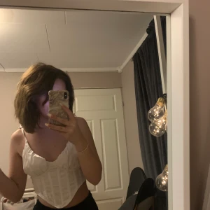 Vit korsett topp - jätte söt topp i strl 34 med knytband uppe vid axlarna,silkesmaterial,aldrig använd med lapp kvar💞