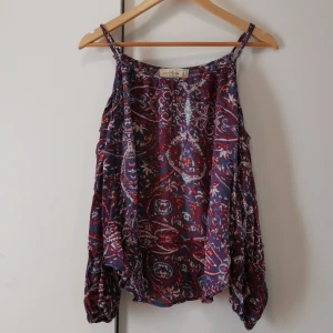 Off shoulder tröja med axelband.  - Mönstrad off shoulder tröja med axelband. Storlek M. Köpt second hand. Fínt skick! 30 kr plus frakt. 