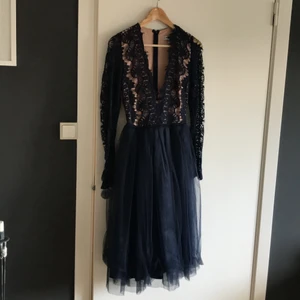 Festklänning - Festklänning med tyllkjol. Överdelen är i spets och långärmad men vacker urringning. Använd en gång på ett bröllop så i princip i nyskick. 