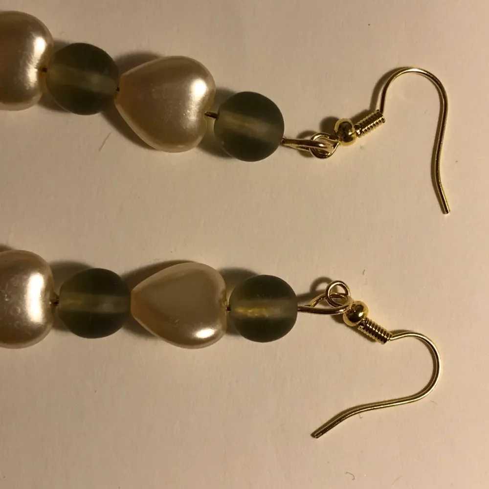 2 guldiga örhängen. 1 par örhängen kostar 30kr och båda kostar då 60kr. Gröna små gulliga klädnypor. Och ett par med gröna pärlor och vita pärlor som är hjärtformade :). Accessoarer.