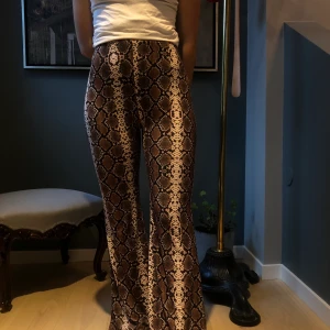 Utsvlngda snakeprintbyxor - Superfina snakeprintbyxor i stretchmaterial. De är i nyskick ☺️ har sytt upp dem (jag är 163cm), går enkelt att sprätta upp.