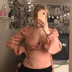 Rosa blus från BikBok - En rosa blus från Bikbok i storlek XS. Den är knappt använd och säljer då mina bröst åker ut, har C-kupa. Inga synliga skador. Man använder den genom att trä snöret igenom hålet på höger sida, som bilden visar. 