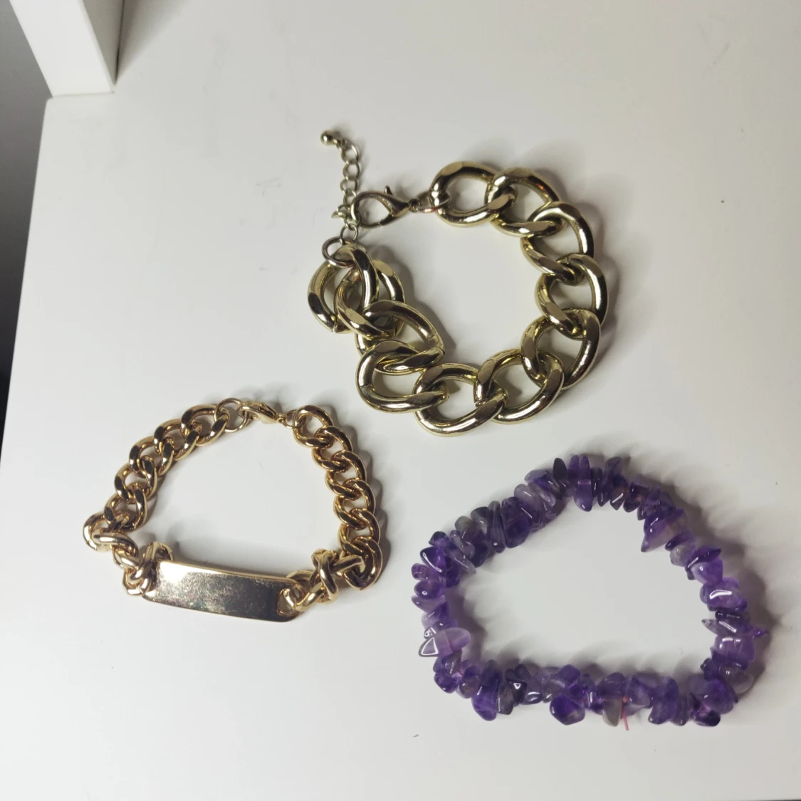 olika armband i guldfärg samt lila  - 90