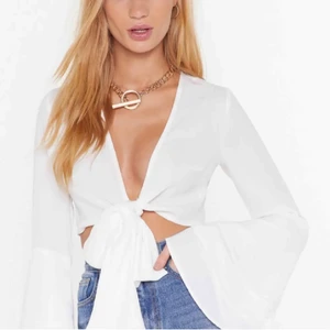 Vit crop top med utsvänga ärmar - Helt ny vit topp med utsvängda ärmar. Väldigt somrig, men är också väldigt snygg att ha över en svart polo eller liknande. Lappen kvar och aldrig använd😇 