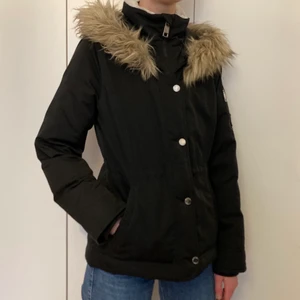 Hollister dunjacka storlek M - Jättefin svart dunjacka från Hollister med fuskpälskrage som går att ta bort 💗 Använd men i jättefint skick, så inga fläckar, hål eller andra skador 😊 Jackan har dragsko i midjan som går att dra åt eller släppa på som man vill och jackan har vitt foder på insidan av kragen. Jackan blir något kort i ärmarna på mig som är 176 och brukar ha S-M i jackor. Köpt för cirka 2000 kr för lite drygt 2 år sedan på Hollisterbutiken i Gallerian. Kostnaden blir 300 kr + frakt (63 kr) 💕