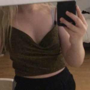 Topp  - Guldglittrig topp från h&m i storlek M. Knappt använd och är i bra skick. Säljs för aldrig kommer till användning.