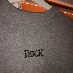 Rockig tröja - Skitsnygg tröja, köpt i England. Texten på ryggen är i teddytyg, texten på framsidan är i stenar! Oversize passform