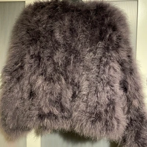 Wos pälsjacka  - Grå pälsjacka från märket Wos. Gjord på äkta fjädrar. Köpte på märkesbutiken Two Angels i Göteborg, för 1000kr. Använd 2 gånger. 