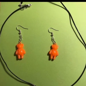 Nallebjörn halsband och örhängen  - Oranga nallebjörn örhängen. Silvriga örhängen & svart halsban. Halsband 25kr och örhängena 35kr om man vill köpa båda kostar det 60kr