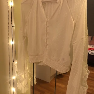 Vit blus  - Vit fin blus med vida ärmar. Knappar går att knäppa, resår i midjan. Säljer en likadan i blått!😇