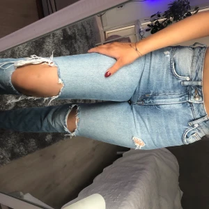 Blåa slitna jeans  - Säljer ett par slitna blå jeans✨skulle säga att själva jeansen färg är lite ljusare än vad det framgår på bilderna. Jeansen är en storlek 34 men (själv är jag en 36) och dessa Jensen sitter bra på mig! Frakt tillkommer!!