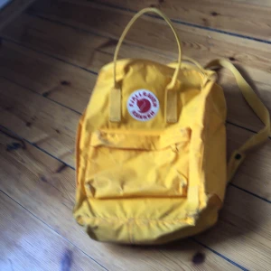 Fjällräven väska - En gul fjällrävenväska med ett sittunderlag i💛.             Bud:200kr