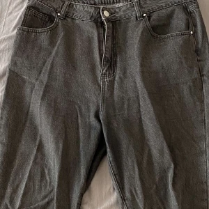 Svarta mom jeans från Boohoo - Hej! Vi är fyra tjejer som säljer begagnade kläder i nyskick för att spara ihop pengar till att kunna starta upp vårat blivande UF företag☀️  på bilderna ser du ett par gråa mom jeans ifrån boohoo.com. Knappt använda på grund av fel storlek tyvärr. Storlek 44🤩 frakt ingår i priset 