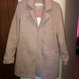 Vila kappa - Helt ny kappa från vila i storlek 38. Prislappen sitter kvar som man kan se. Fickorna är sydda men går att spreta upp lätt då jag gjort det på min gråa kappa. Fin rosa fårg och väldigt skön. Ordinarie pris är 650kr.   Köparen betalar frakt!!!!