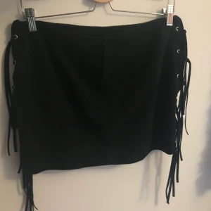 Mocka tjock med fransar - En jättefin  kjol från H&M i mocka material (fejk)! Kjolen har fransar på sidan och en dragkedja där bak. Nästan aldrig använd så den är i nyskick! Köparen betalar frakt❤️