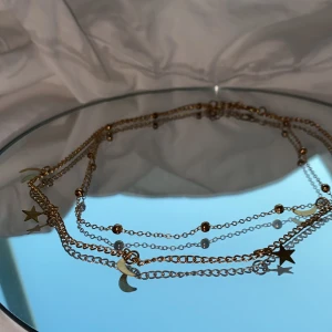 Dubbelt halsband i guld - Guldigt halsband med stjärnor och månar, lite missfärgad.