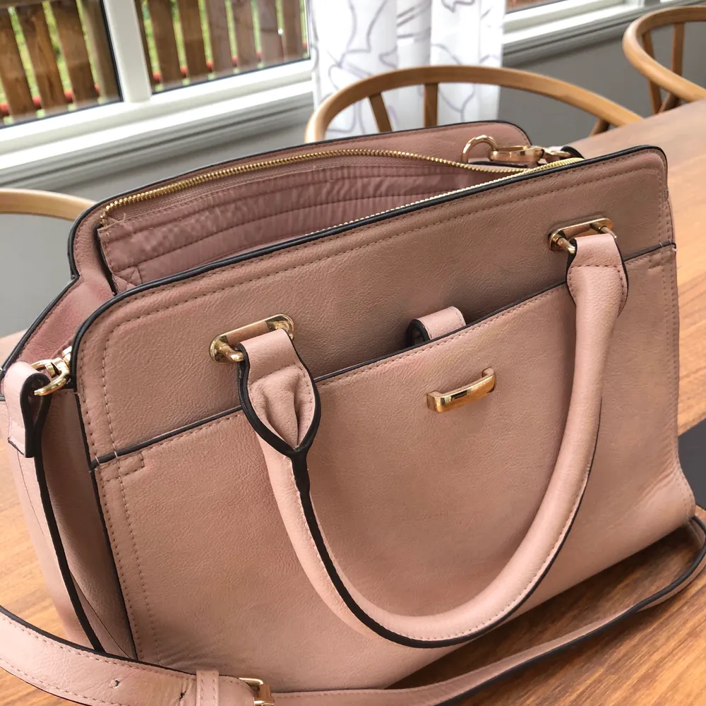 Rosa handväska med gulddetaljer, medföljer axelrem också! Knappt använd så är i fint skick! . Väskor.