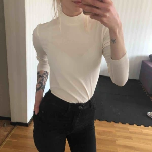  - Tunn vit-beige polotröja, endast testad framför spegeln men aldrig använd. Ribbat mönster, lätt transparent.  