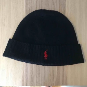  - En klassisk Ralph Lauren mössa. Mössan är i färgen marinblå med ett rött märke! 💖