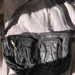  - NuNoo väska, klassiska modellen. Använd ett fåtal gånger. Medföljer även ett längre band till den 