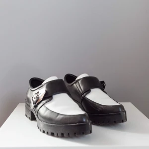  - Svartvita skor (liknar creepers) med spetsig tå och chunky metalldetaljer • Fint skick förutom några få blemmor (se bild) 