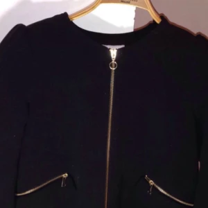  - En kappa från H&M. Den har 2 fickor och en dragkedja. Köparen står för frakt.