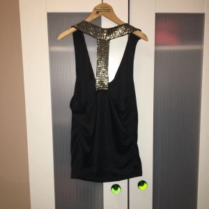  - Partytopp med öppen rygg som glittrar med paljettliknande stenar. 