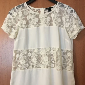  - Vit topp med broderade blommor