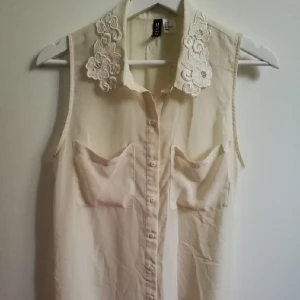  - Genomskinlig, krämvit topp med fina detaljer. Den slutar strax nedanför rumpan baktill och framtill slutar den strax före. Använd 1 gång. Finns i Borlänge, kan skickas mot porto.